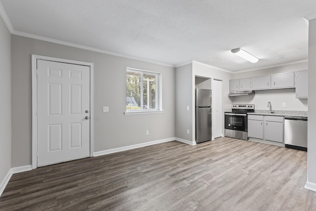 kitchen with sink, ornamental molding, light hardwood / wood-style floors, and appliances with stainless steel finishes