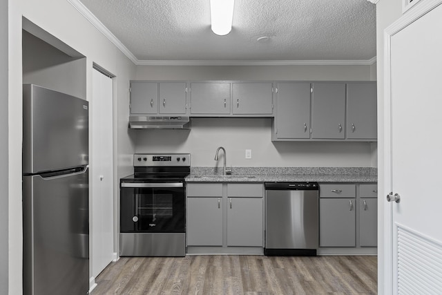 kitchen featuring sink, ornamental molding, a textured ceiling, and appliances with stainless steel finishes