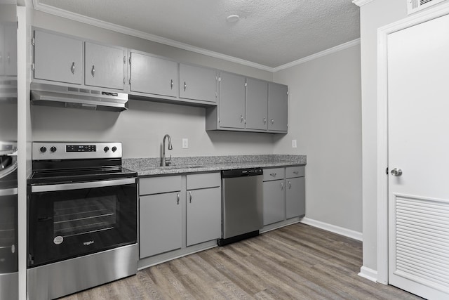 kitchen with sink, gray cabinetry, stainless steel appliances, crown molding, and a textured ceiling