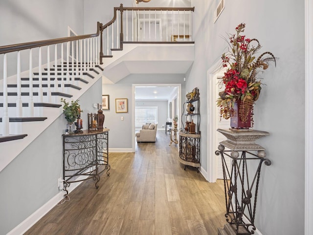 entryway with hardwood / wood-style flooring and a towering ceiling