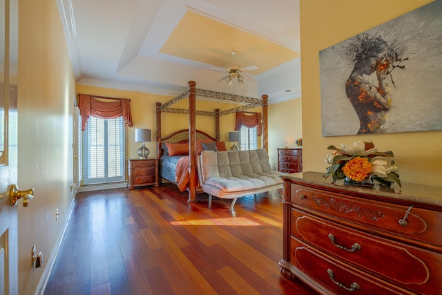 bedroom featuring a raised ceiling, ornamental molding, hardwood / wood-style floors, and ceiling fan