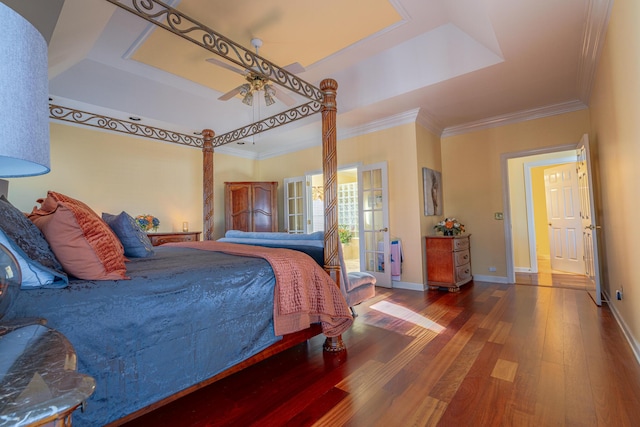 bedroom featuring hardwood / wood-style flooring, ornamental molding, a raised ceiling, and ceiling fan