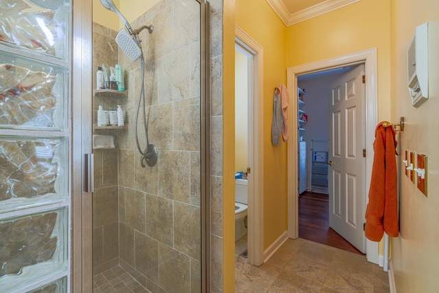 bathroom featuring ornamental molding, toilet, and an enclosed shower