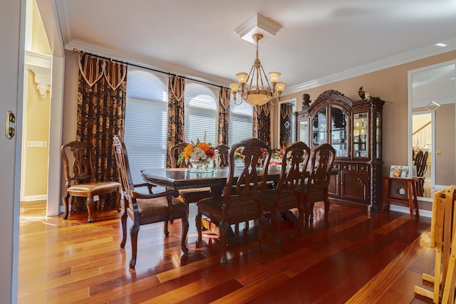 dining space featuring crown molding, hardwood / wood-style floors, and a notable chandelier