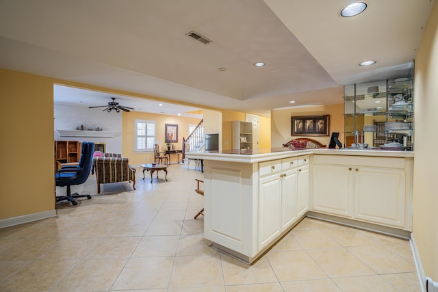 kitchen with ceiling fan, kitchen peninsula, and light tile patterned floors