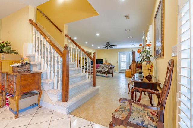 stairway featuring ceiling fan and tile patterned flooring