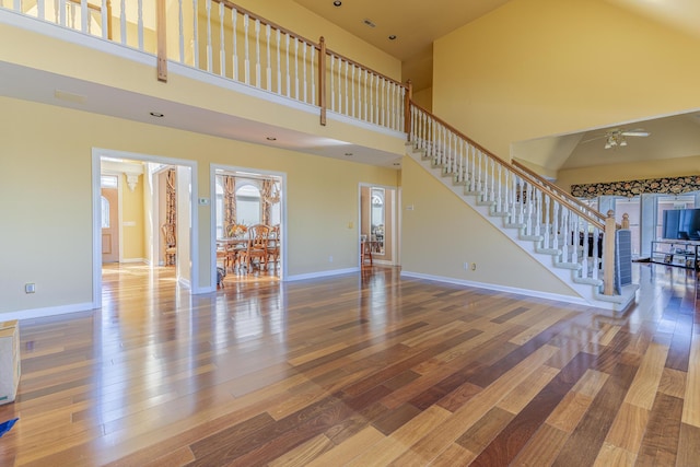 unfurnished living room with hardwood / wood-style flooring and a high ceiling