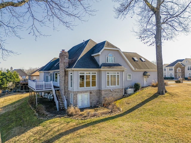 rear view of property featuring a yard and a deck