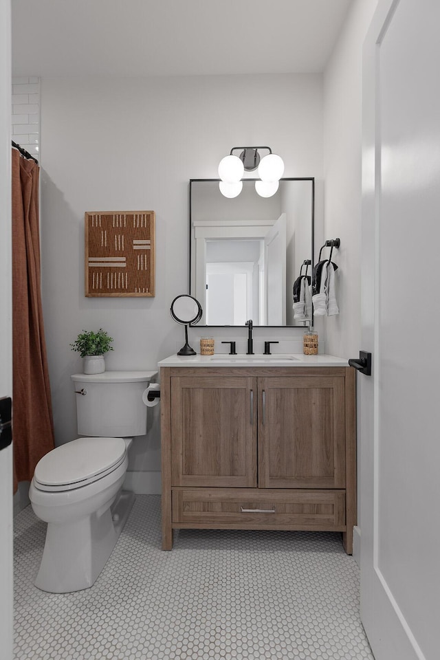 bathroom featuring tile patterned flooring, vanity, and toilet