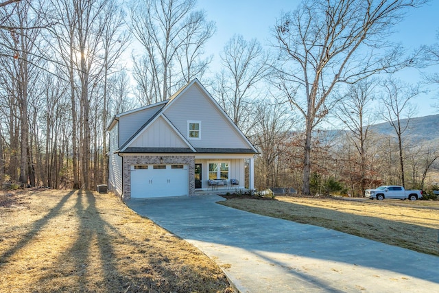 view of property featuring a garage, a mountain view, covered porch, and a front lawn