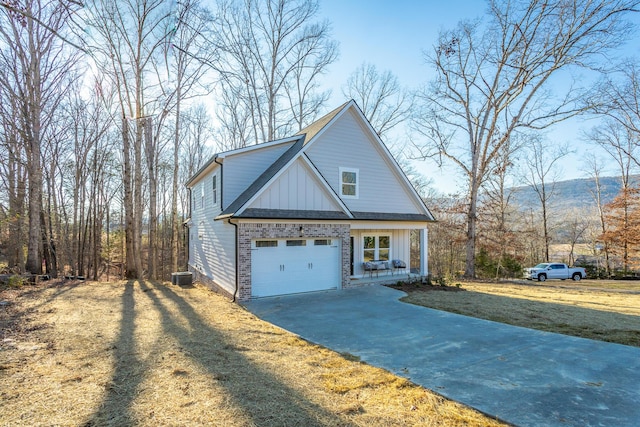 view of front facade featuring cooling unit, a garage, and a front yard