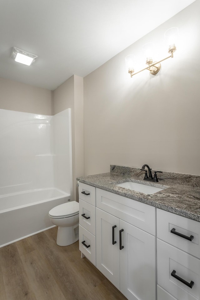 full bathroom featuring shower / tub combination, wood-type flooring, toilet, and vanity