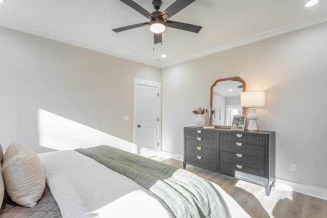 bedroom with ornamental molding, light wood-type flooring, and ceiling fan