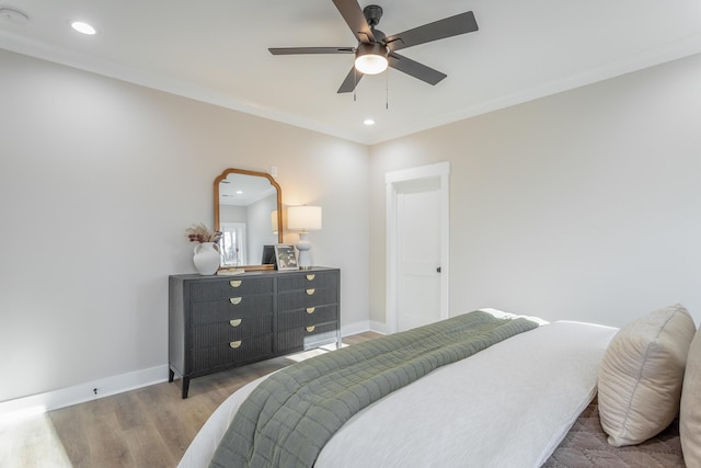 bedroom with hardwood / wood-style floors, crown molding, and ceiling fan