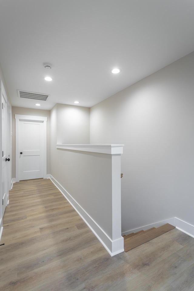 corridor with light hardwood / wood-style floors