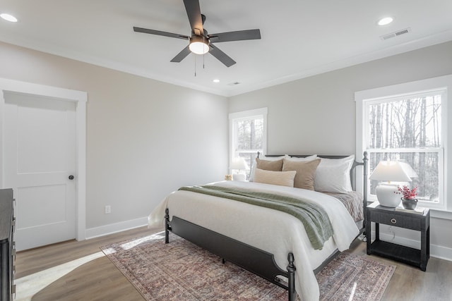 bedroom featuring crown molding, ceiling fan, and light hardwood / wood-style flooring