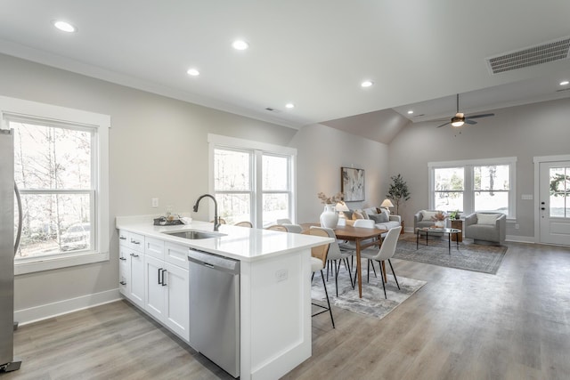 kitchen with sink, light hardwood / wood-style flooring, appliances with stainless steel finishes, white cabinetry, and kitchen peninsula