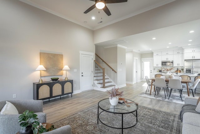 living room featuring crown molding, ceiling fan, and hardwood / wood-style flooring