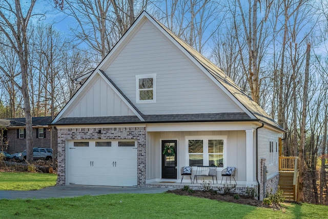 view of front facade with a porch, a garage, and a front lawn