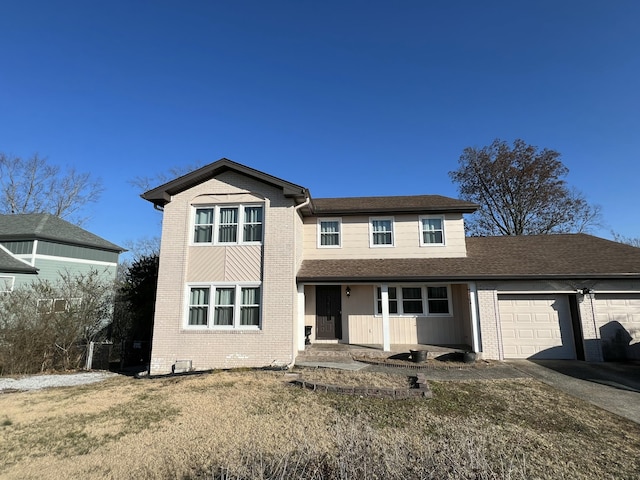 traditional-style home with an attached garage, brick siding, a shingled roof, driveway, and a front lawn