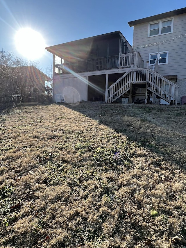 rear view of house with a sunroom and a yard