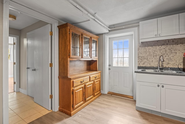 kitchen with white cabinetry, brown cabinets, and a sink