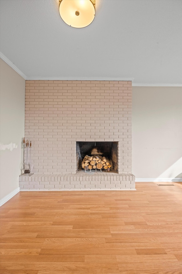 details featuring a fireplace, baseboards, crown molding, and wood finished floors