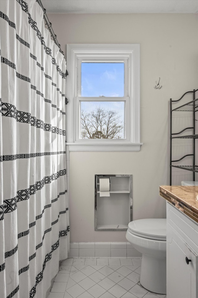 full bath with baseboards, vanity, and toilet