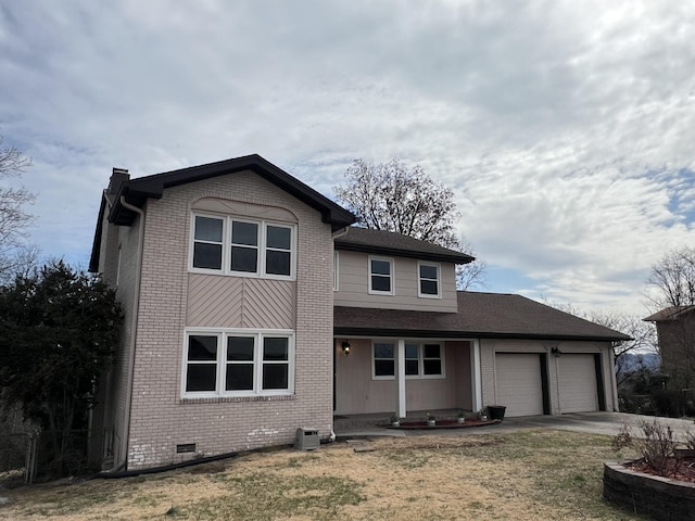 traditional-style home featuring brick siding, crawl space, a garage, driveway, and a front lawn