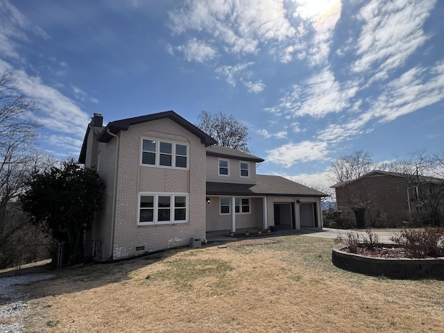 back of property featuring a lawn, a chimney, an attached garage, crawl space, and brick siding