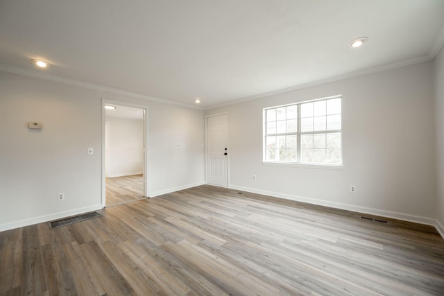 unfurnished room featuring ornamental molding and light wood-type flooring