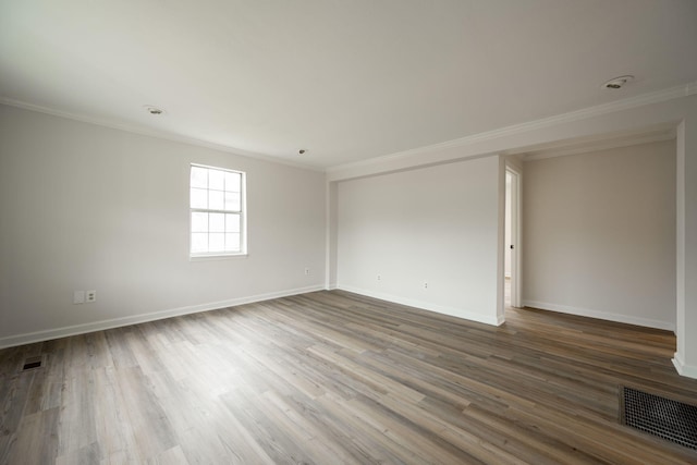 spare room featuring crown molding and wood-type flooring