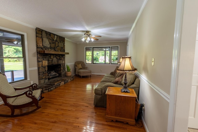 446 Jamestown Rd, Menlo, GA 30731 - living room featuring hardwood / wood-style flooring, crown molding, a stone fireplace, and ceiling fan