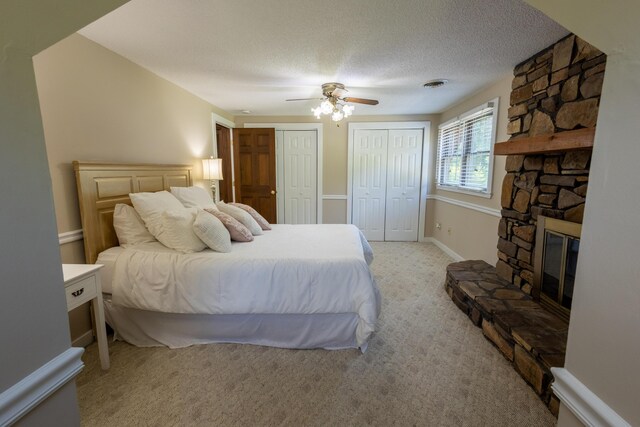 446 Jamestown Rd, Menlo, GA 30731 - carpeted bedroom featuring multiple closets, ceiling fan, a stone fireplace, and a textured ceiling