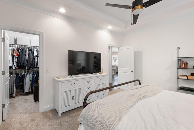 carpeted bedroom featuring crown molding, ceiling fan, a spacious closet, and a closet