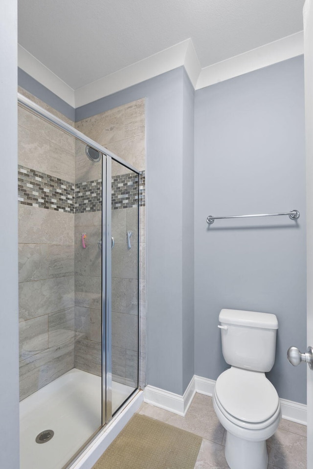 bathroom with tile patterned flooring, a shower with shower door, ornamental molding, and toilet