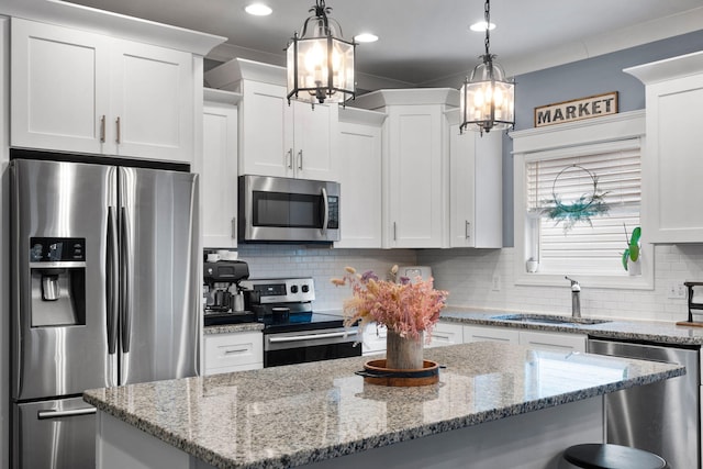 kitchen featuring stainless steel appliances, white cabinets, and hanging light fixtures