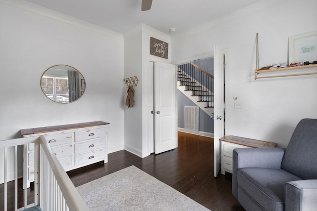 bedroom with crown molding, dark wood-type flooring, and ceiling fan