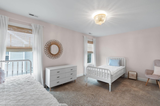 carpeted bedroom with visible vents and baseboards