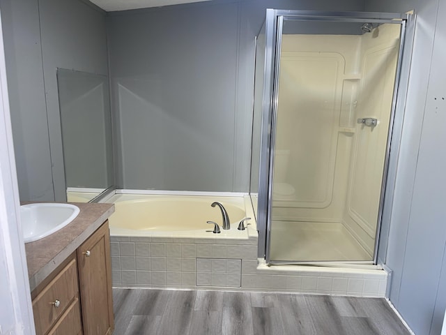 bathroom featuring hardwood / wood-style flooring, vanity, and shower with separate bathtub