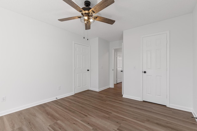 unfurnished bedroom with dark hardwood / wood-style flooring and ceiling fan