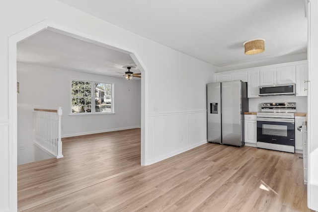 kitchen with ceiling fan, stainless steel appliances, light hardwood / wood-style floors, and white cabinets