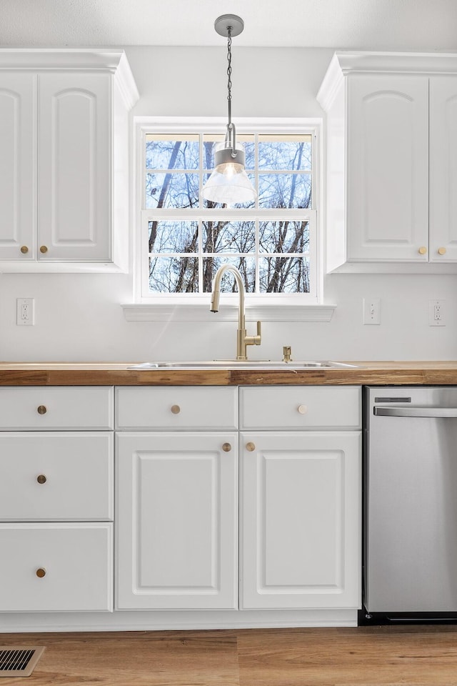 kitchen featuring white cabinetry, dishwasher, sink, and hanging light fixtures