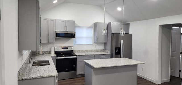 kitchen featuring stainless steel appliances, a center island, gray cabinetry, and light stone counters