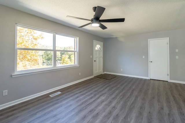 spare room featuring ceiling fan, dark hardwood / wood-style floors, and a textured ceiling