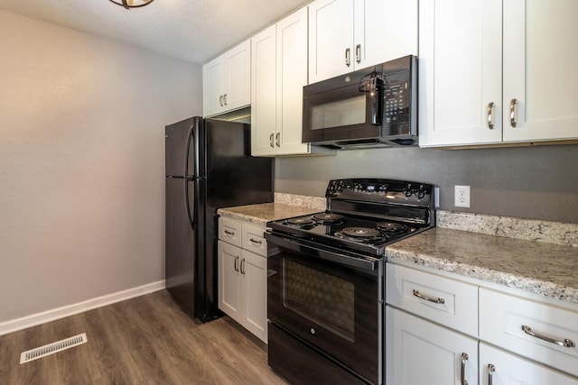 kitchen with light stone countertops, black appliances, a textured ceiling, white cabinets, and dark hardwood / wood-style flooring