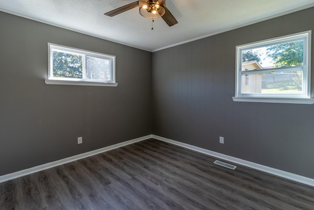 spare room featuring ceiling fan, a healthy amount of sunlight, and dark hardwood / wood-style floors