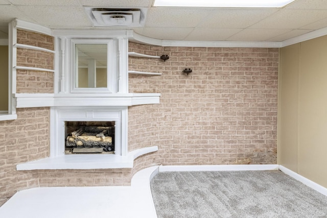 interior space featuring a paneled ceiling and brick wall