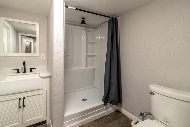 bathroom with vanity, a shower with curtain, a textured ceiling, and toilet