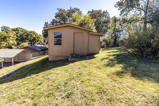 view of outbuilding with a carport and a lawn